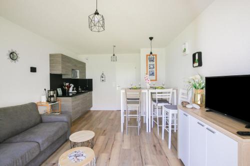 un salon et une cuisine avec un canapé et une table dans l'établissement Ondine, à Mimizan