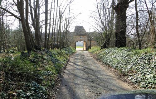 un chemin de terre menant à un bâtiment avec une arche dans l'établissement Beautiful Home In Domfront En Champagne, à Domfront-en-Champagne