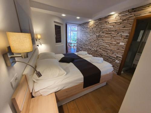 a bedroom with a bed and a brick wall at Apartma Kočevar Portorož in Portorož