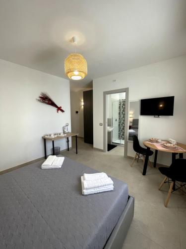a bedroom with a bed and a table and a television at Alguer 74 in Alghero