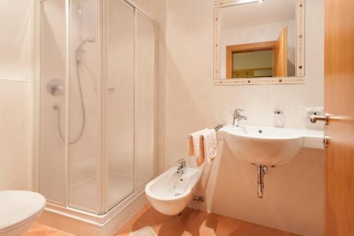 a bathroom with a sink and a shower and a toilet at Alpenspitz Appartements - Garni - B&B in Racines