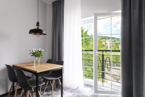 a dining room with a table and chairs and a window at Hotel Vivaldi in Karpacz