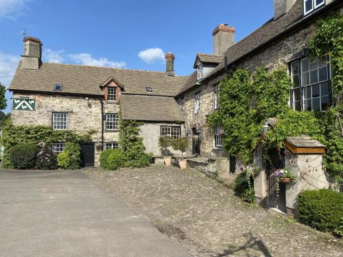 an old stone house with a driveway in front of it at Three Cocks Hotel in Brecon