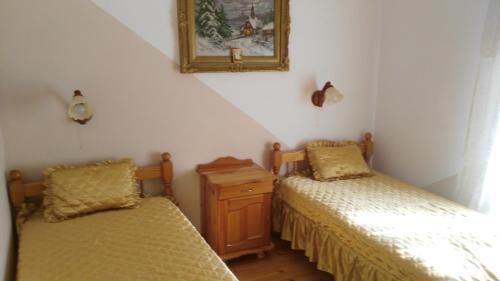 a bedroom with two beds and a picture on the wall at Къща под наем PETROVA in Cherven