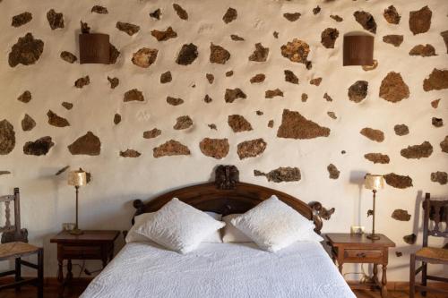 una camera con letto e parete con rocce di Joya del Jable a Tao