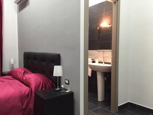 a bedroom with a bed and a sink and a mirror at B&B Napoli Binario 1 in Naples