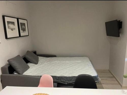 a bedroom with a bed and a couch at Apartamento Puertas del Orbigo 1 in Carrizo de la Ribera