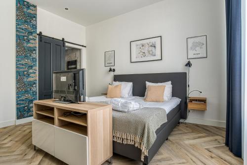 1 dormitorio con 1 cama y escritorio con TV en Hosted by Wendy Prins Willem 1 en Scheveningen