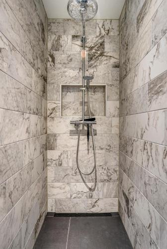 a shower in a bathroom with a stone wall at Hosted by Wendy Prins Willem 1 in Scheveningen