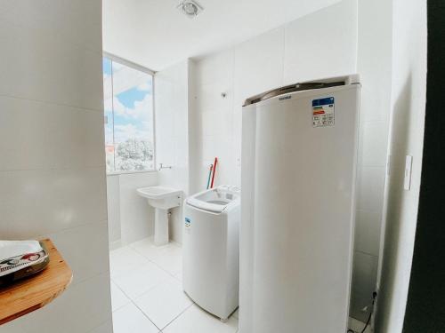 uma casa de banho branca com um WC e um frigorífico em Hotel APART Zuccolotto 202 em Aracruz