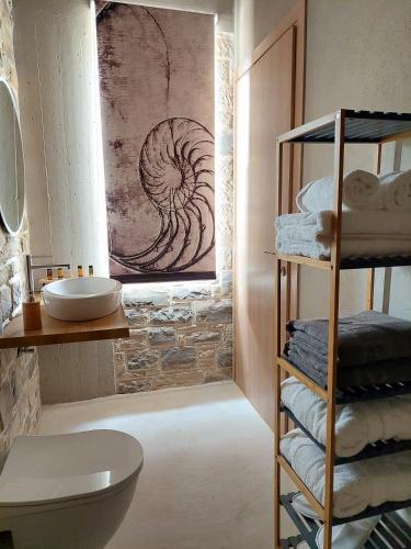 a bathroom with a sink and a shelf with towels at Phaestias Terra Villas in Kalamaki