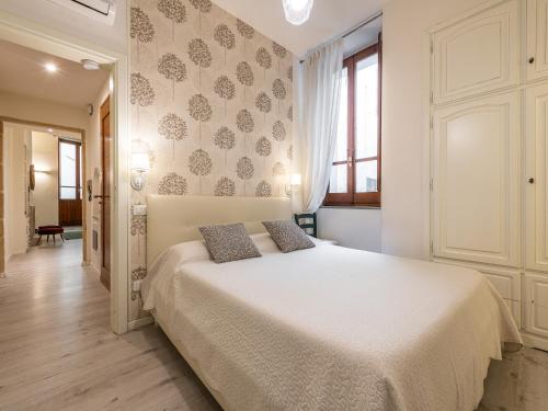 a bedroom with a white bed with two pillows on it at Marco's stylish home In the heart of Cagliari in Cagliari
