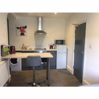 a kitchen with a table and a chair in it at Heber Apartment in Goole