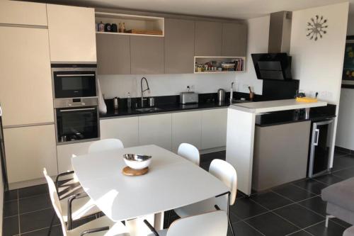 a kitchen with a white table and white chairs at Annecy centre, Appartement en attique avec vue panoramique in Annecy