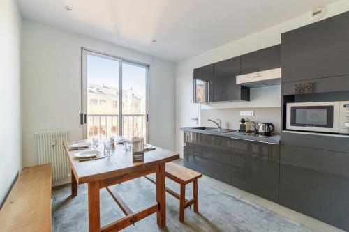 - une cuisine avec une table en bois dans une chambre dans l'établissement Appartement du Quai - Welkeys, à Lyon