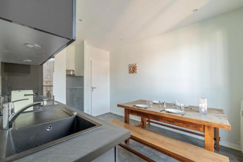 - une cuisine avec un évier et une table en bois dans l'établissement Appartement du Quai - Welkeys, à Lyon