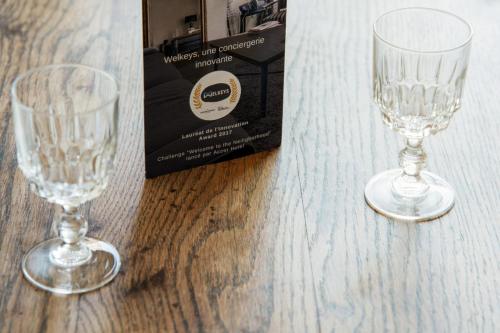 deux verres à vin posés sur une table à côté d'une boîte dans l'établissement Appartement du Quai - Welkeys, à Lyon