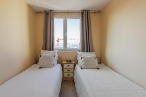 deux lits dans une chambre avec une fenêtre dans l'établissement Appartement Jaurès vue sur la Seine - Welkeys, à Clichy