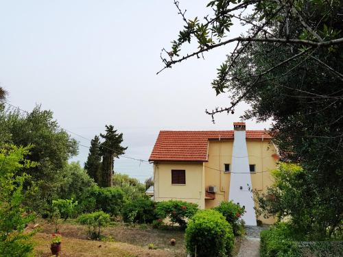 a small yellow house with a red roof at Stefanos Apartments by SV Alians in Agios Gordios