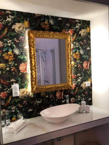 a bathroom with a sink and a mirror on a wall at Les chambres Berguoises Chambre Rez-de-chaussée au coeur de Bergues in Bergues