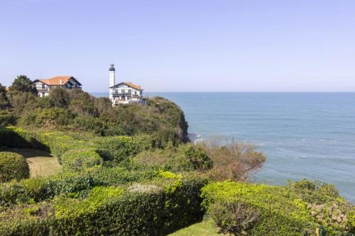 a house on a hill next to the ocean at Bright T2 with balcony and sea view in Biarritz in Biarritz