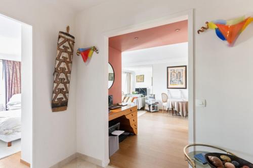 - une chambre avec un bureau et une chambre avec un lit dans l'établissement Appartement Boylesve - Welkeys, à Paris