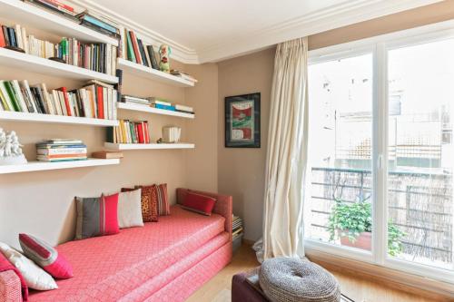 - un salon avec un canapé rouge et une fenêtre dans l'établissement Appartement Boylesve - Welkeys, à Paris