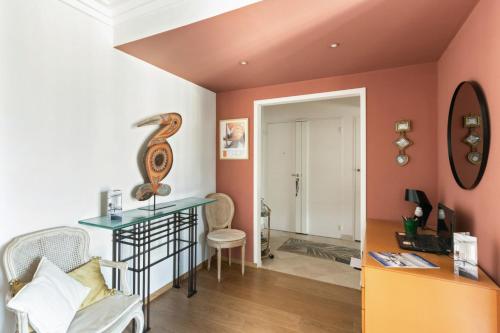 - un salon avec des murs orange et une table en verre dans l'établissement Appartement Boylesve - Welkeys, à Paris