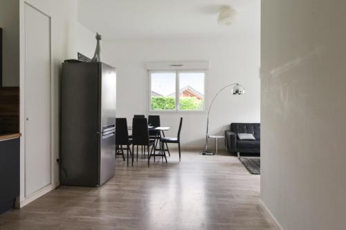 uma sala de estar com um frigorífico preto e uma mesa em Spacious 3-rooms with garden close to Lille em Lille