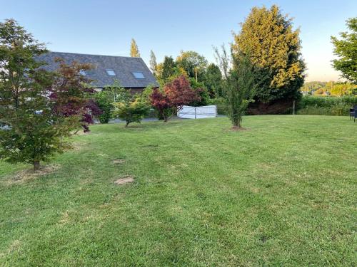 a large yard with trees and a house at Gîte La Roche in Reffuveille