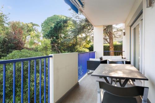 a balcony with a wooden table and chairs at Breathtaking 2br with terrace close to beaches in Antibes