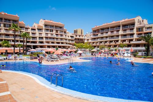 a large swimming pool with people in a resort at Tenerife South Apartments in Playa de las Americas
