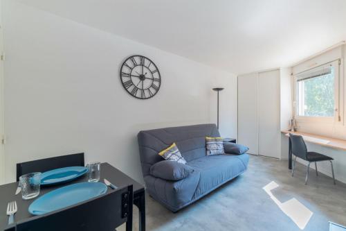een woonkamer met een blauwe bank en een tafel bij Bright and modern studio close to Part-Dieu - Welkeys in Lyon
