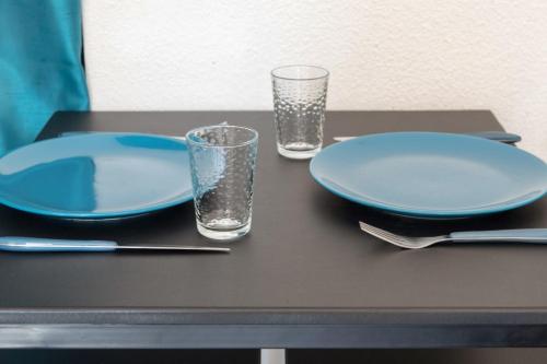 - une table avec deux assiettes et deux verres dans l'établissement Studio Baraban - Welkeys, à Lyon