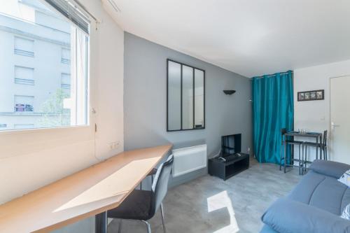 een kamer met een bureau, een bank en een raam bij Bright and modern studio close to Part-Dieu - Welkeys in Lyon