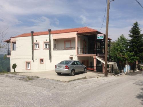 a car parked in front of a building at Πανδοχείο Λίμνης Πλαστήρα in Kastaniá