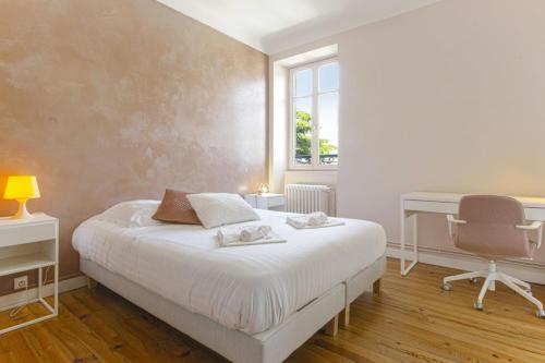 une chambre avec un lit, un bureau et une chaise dans l'établissement Appartement Bourbon - Welkeys, à Bayonne