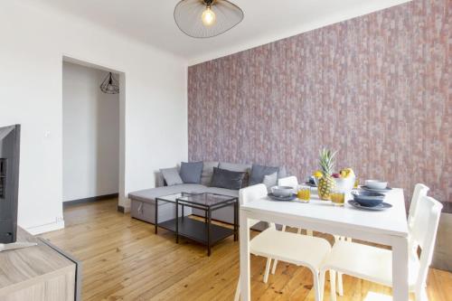 un salon avec une table blanche et un canapé dans l'établissement Appartement Bourbon - Welkeys, à Bayonne