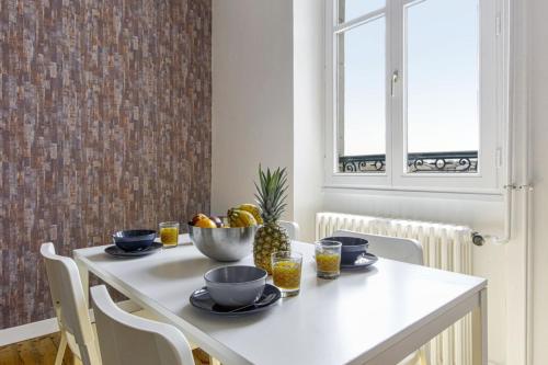 une table de salle à manger avec un bol de fruits dessus dans l'établissement Appartement Bourbon - Welkeys, à Bayonne