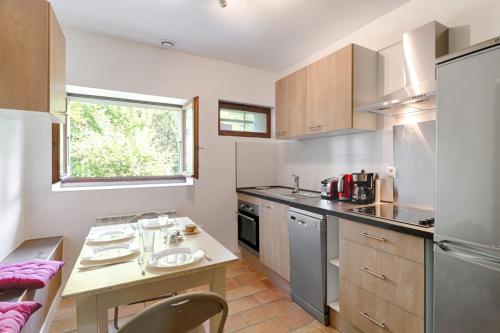 a small kitchen with a table and a sink at Modern studio in a nice farm close to city-center - Welkeys in Annecy