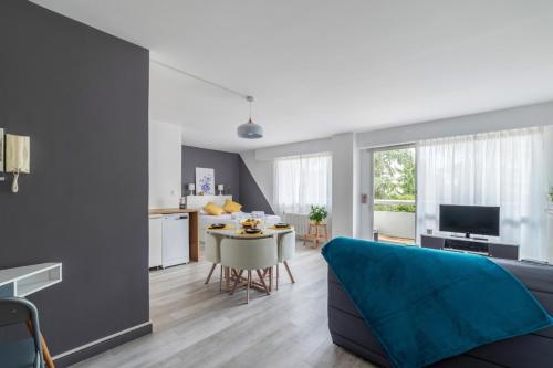 a living room with a blue couch and a table at Nice studio with balcony and parking in Villeurbanne near Lyon - Welkeys in Villeurbanne