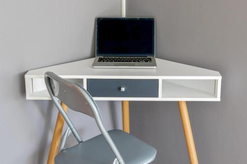 un ordinateur portable installé au-dessus d'un bureau blanc dans l'établissement Studio Condorcet - Welkeys, à Villeurbanne
