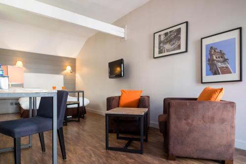ein Wohnzimmer mit einem Tisch und Stühlen in der Unterkunft Beffroi - Cosy studio close to Vieux Lille - Welkeys in Lille