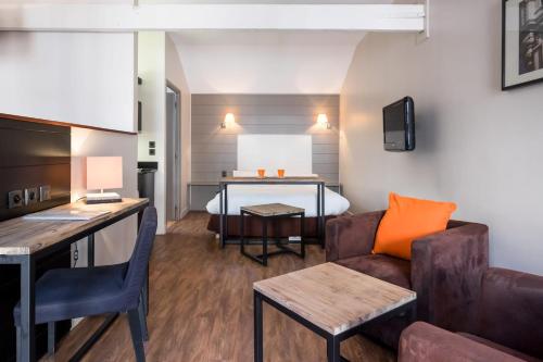 ein Wohnzimmer mit einem Sofa und einem Bett in der Unterkunft Beffroi - Cosy studio close to Vieux Lille - Welkeys in Lille