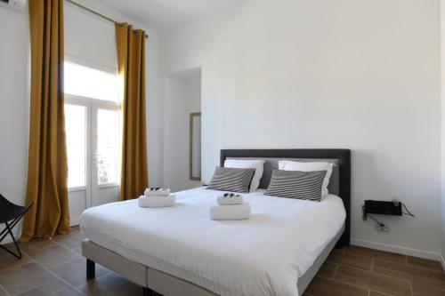 une chambre avec un grand lit blanc avec deux oreillers dans l'établissement Appartement Carnot - Welkeys, à Cannes