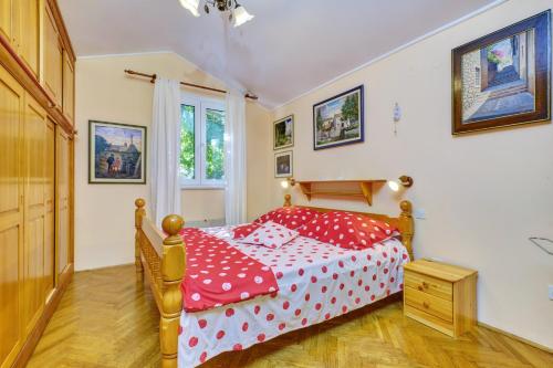 a bedroom with a red bed with polka dot sheets at Apartment Goga - Seaview & Parking in Mali Lošinj