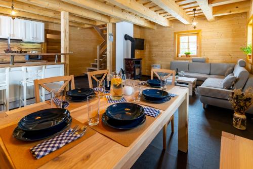 jadalnia i salon ze stołem z talerzami i kieliszkami w obiekcie Chalúpka na Lúke w Liptowskim Mikulaszu