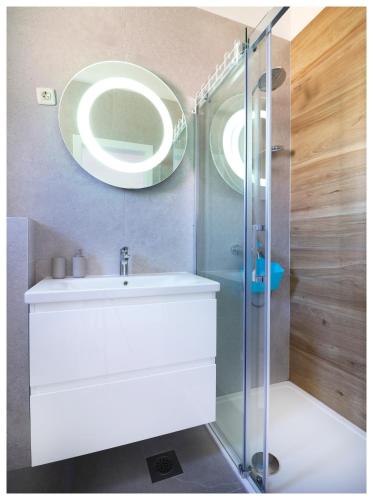 a bathroom with a sink and a glass shower at Apartment Jerko 2 in Primošten
