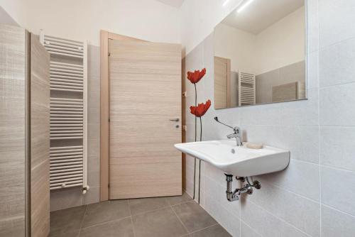 een witte badkamer met een wastafel en een spiegel bij Nonno Bigi Papavero in Tremosine Sul Garda