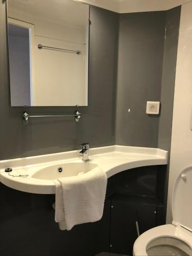une salle de bain avec un lavabo et un miroir et des toilettes dans l'établissement Auberge d+ Valloire-Galibier, à Valloire